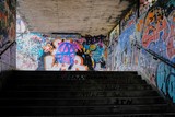 Fototapeta Młodzieżowe - Abandoned underground passageway with old graffiti and old postcards on the walls