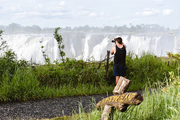 Male adventure photographer exploring and photographing Victoria Falls, Zimbabwe. 