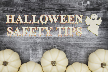 Wall Mural - Halloween safety tips  message with white pumpkins