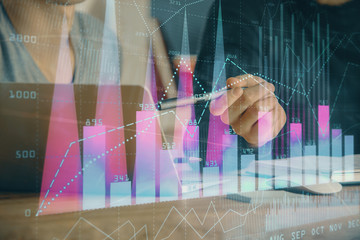 Forex graph with businessman typing on computer in office on background. Concept of analysis. Double exposure.