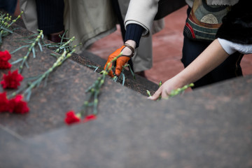 Wall Mural - Red roses and carnation symbol of mourning - laying flowers to the monument, telephoto