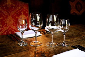 Four gleaming wine glasses on a table in a upmarket restaurant