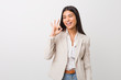 © Asier - Young business arab woman isolated against a white background winks an eye and holds an okay gesture with hand.