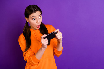 Wall Mural - portrait of astonished worried youth girl use her phone play speed race game wonder if she loses hav