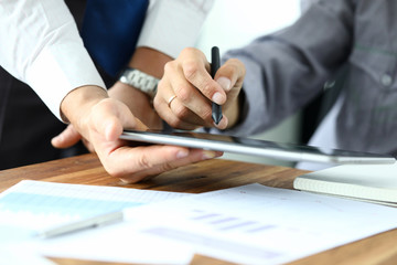 Focus on workers hands holding tablet. Manager giving for signature e-documents. Director signing important contract. Business concept. Blurred background