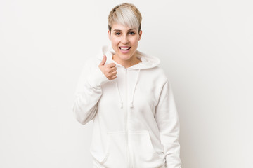 Wall Mural - Young curvy woman wearing a white hoodie smiling and raising thumb up