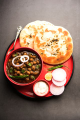 Wall Mural - Pindi Chole Kulche or roadside choley Kulcha popular in India and pakistan is a popular streetfood. It's a spicy Chickpea or chana curry served with Indian Flat Bread. selective focus