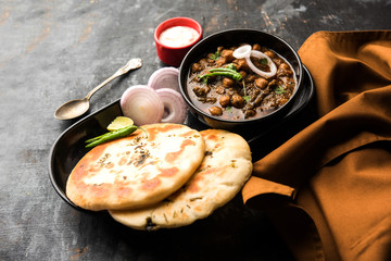 Pindi Chole Kulche or roadside choley Kulcha popular in India and pakistan is a popular streetfood. It's a spicy Chickpea or chana curry served with Indian Flat Bread. selective focus