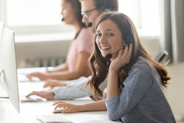 Wall Mural - call center employee female sitting at workplace pose for camera
