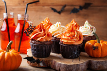 Halloween Cupcakes And Pumpkins On Wooden Background. Sweets For Holiday Party.
