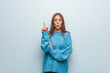 © Asier - Young pretty woman wearing a blue sweater having a great idea, concept of creativity