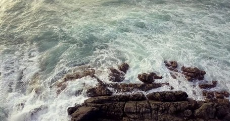 Canvas Print - Stationary close up drone video of waves hitting the rocks at sunset in Saint Martin Sint Maarten  