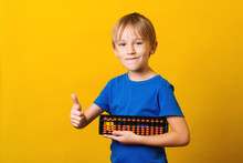 Cute Boy Holds Abacus. Kid Study At Mental Arithmetic School.