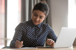 © fizkes - Young indian businesswoman student working studying with laptop making notes