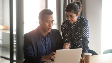 Indian mentor coworker talk help black intern explain computer work