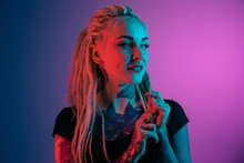 Caucasian Young Woman's Portrait On Gradient Background In Neon Light. Beautiful Female Model With Unusual Look. Concept Of Human Emotions, Facial Expression, Sales, Ad. Looking Ar Side, Smiles.