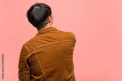 Fotografía Young chinese man wearing a jacket from behind thinking about something