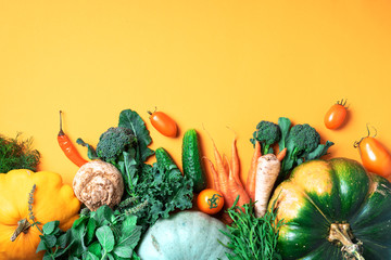 Wall Mural - Autumn vegetables on trendy yellow background. Top view. Vegan and vegetarian diet, harvest concept. Ingredients for cooking - pumpkin, tomatoes, cucumber, pepper, kale, broccoli, celery