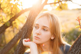 Fototapeta Dmuchawce - Portrait of beautiful young woman near the tree outdoors