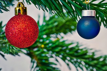 Two Christmas toys in the shape of a red shiny and blue ball for New Year s decoration closeup