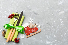 Top View Of New Year Dinner On Cement Background. Festive Cutlery On Napkin With Christmas Decorations And Toys. Family Holiday Concept With Copy Space