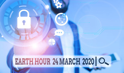 Text sign showing Earth Hour 24 March 2020. Business photo text Celebrate Sustainability Save the Planet Lights Off Male human wear formal work suit presenting presentation using smart device