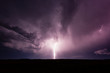 Powerful bolt of lightning striking the ground during thunderstorm.
