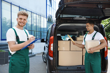 Poster - Young couriers with parcels near delivery car outdoors