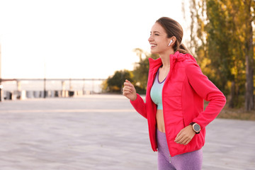 Sticker - Young woman with wireless headphones listening to music outdoors. Space for text