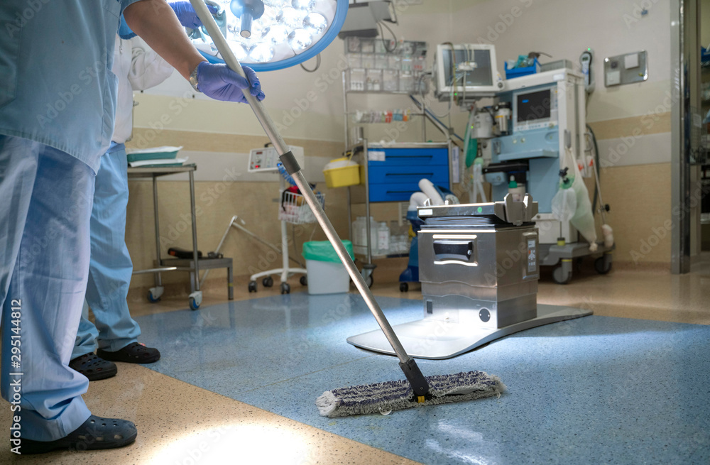 Concept photo of A hospital worker doing cleaning in operation room - obrazy, fototapety, plakaty 