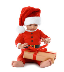 Festively dressed baby with gift box on white background. Christmas celebration