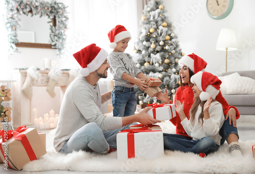 Fotografía Happy family with children and Christmas gifts on floor at home