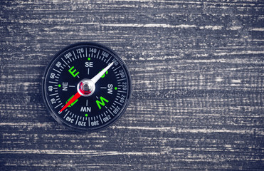 compass on wood background concept for direction, travel, guidance or assistance