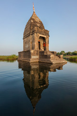 Fototapete - Small Hindu temple in the middle of the holy Narmada River, Maheshwar, Madhya Pradesh state, India