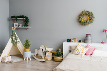The Interior Of The Bedroom Or Children's Room Decorated For Christmas Or New Year: Bed, Wigwam, Children's Swing Horse, Christmas Wreath On The Wall