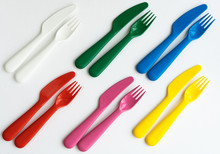 Colored Bright Plastic Dishes Beautifully Laid Out On A White Background. Knives, Forks, Spoons. Menu Concept For Bar And Restaurant. Free Space For Text. 