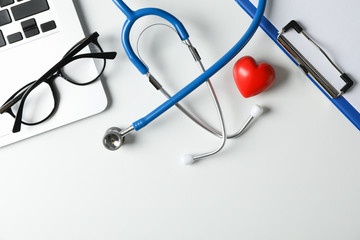 Wall Mural - Stethoscope, laptop, tablet, pen and heart on white background, space for text