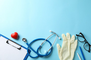 Wall Mural - Stethoscope and glasses on blue background, space for text. Doctor workplace