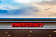 A hospital's emergency ward sign by the evening sky