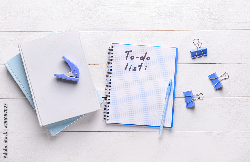 Empty to do list and stationery on white wooden background