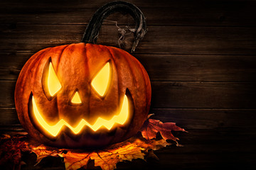 Wall Mural - Scary horror background with Halloween pumpkin jack o lantern, placed on a wooden crate.