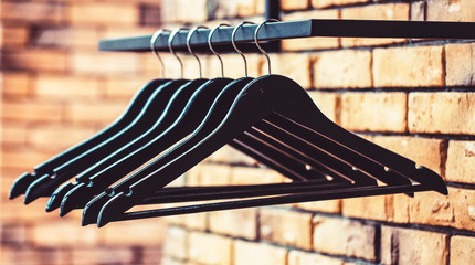 Wooden coat hanger clothes. Fashionable different types of hanger. Wood Hangers coat. Many wooden black hangers on a rod. Store concept, sale, design, empty hangers. Black friday.