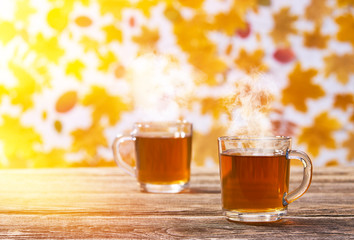 two glass cup on a wooden board on a autumn background