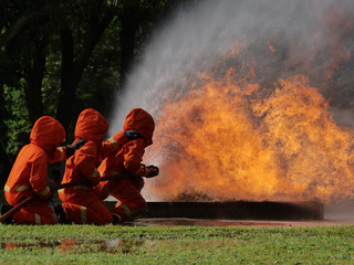 Wall Mural - firefighter spray water to fire burning car workshop fire training