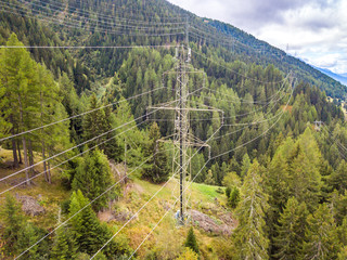 Wall Mural - Aerial view of power line and pylon in alpine valley of Goms in Switzerland. Power grid through alps. 