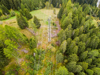 Wall Mural - Aerial view of power line and pylon in alpine valley of Goms in Switzerland. Power grid through alps. 