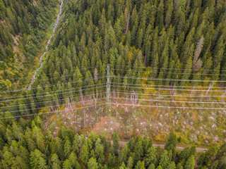 Wall Mural - Aerial view of power line and pylon in alpine valley of Goms in Switzerland. Power grid through alps. 