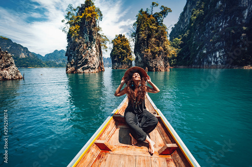 Fotografía happy young woman tourist in asian hat on the boat at lake