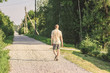 © Michael Kachalov - A man in shorts is walking along a road in the countryside