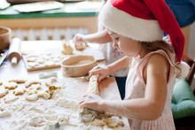Kids Cooking Christmas Cookies In Cozy Kitchen. Child Prepares Holiday Food For Family. Cute Little Girls Bake Homemade Festive Gingerbreads. Lifestyle Moment. Santa Helper. Children Chef Concept